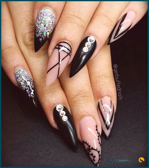 Diseño de uñas acrílicas negras y plateadas.
