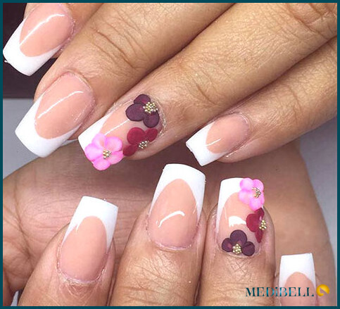 Diseño de uñas acrílicas con punta francesa y detalles florales.