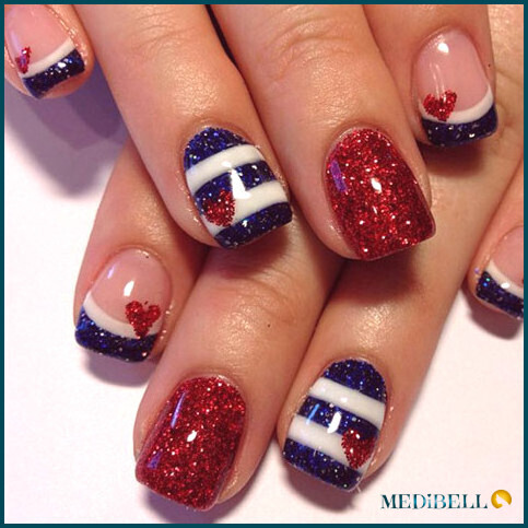 Diseño de uñas acrílicas con purpurina blanca, azul y roja.