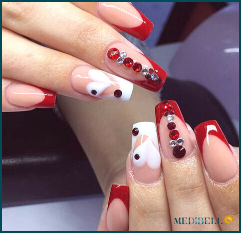 Diseño de uñas acrílicas con detalles de joyas de punta roja
