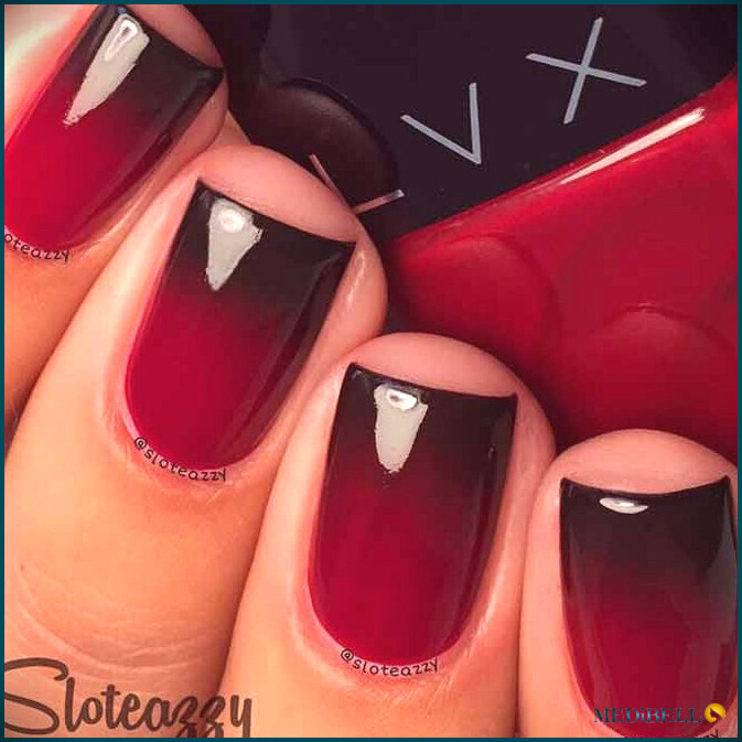 Diseño de uñas cortas en degradado negro y rojo.