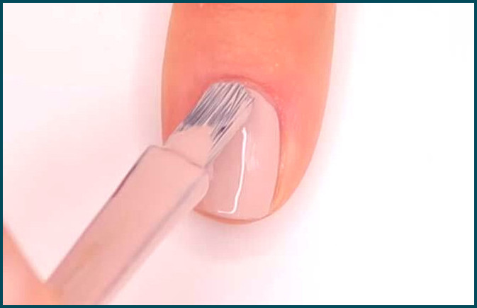 El paso 2 del proceso de uñas ombre es aplicar un par de capas de esmalte de uñas nude.