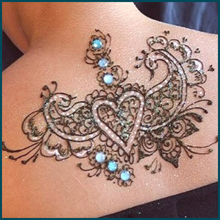 Diseño de henna de corazón con piedras y brillos.